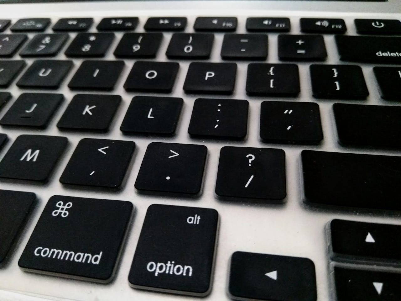 Detailed close-up of a black keyboard, showcasing keys and symbols on a laptop.